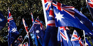 Protesters wave flags as they march against immigration in Sydney on Sunday.