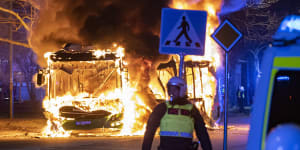 Riot police watch a city bus burn on a street in Malmo over the weekend.