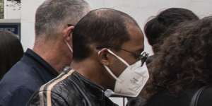 People wait outside a COVID-19 vaccination center for foreign nationals in Shanghai,China.