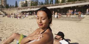 Serene Amaral from Waterloo applies some sunscreen at Coogee Beach on Sunday,when temperatures hit 38 degrees.