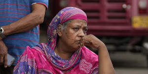 A Sri Lankan woman sits in protest outside a police station demanding cooking oil. 