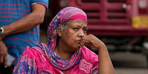 A Sri Lankan woman sits in protest outside a police station demanding cooking oil. 