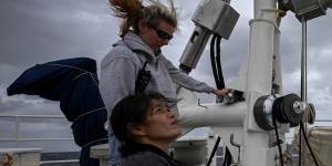 Second mate Katharina Koenig and deck hand Tim Atichakaro raise the the Rainbow Warrior’s sails.