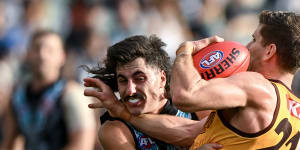 Luke Breust of the Hawks is tackled by Lachie Jones.