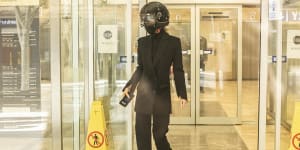 Gemma Wright,the partner of surgeon William Mooney,leaves the hearing wearing a motorcycle helmet. 