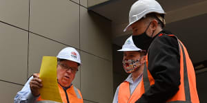 NSW Building Commissioner David Chandler,left,talks about the removal of cladding from a Darlington apartment building.