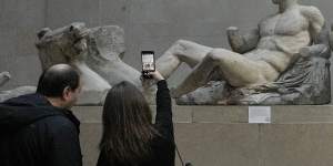 A visitor takes a picture of sculptures that are part of the Parthenon Marbles at the British Museum in London.