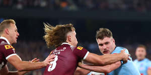 Angus Crichton of the Blues is tackled by Reuben Cotter of the Maroons.