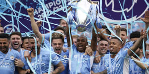 Manchester City players celebrate with the 2022 Premier League trophy.