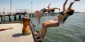 Friends Aoife Greenwood,Isla Barlow and Opal Tieu jump off the pier at Port Melbourne in November.