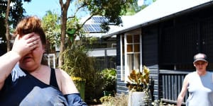 Kym Strow tries to salvage what she can from her Lismore home after the February flood last year.