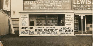 Kiwi shoe polish founders William Ramsay (left) and Hamilton McKellan in the first Kiwi shop in Elizabeth Street,Melbourne,in 1909 with a billboard of arch rival Nugget brand at upper left.
