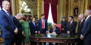 Donald Trump signs documents in the President’s Room at the US Capitol.