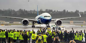 Boeing employees and family members cheer the 777X after it landed at Boeing Field in Seattle,completing its first flight on Saturday,Jan. 25,2020. (Mike Siegel/The Seattle Times via AP)