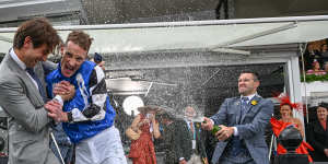 Jockey Mark Zahra is sprayed with champagne after winning the Cup aboard Gold Trip. 