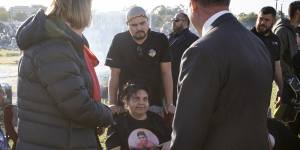 Mechelle Turvey is greeted by Police Minister Paul Papalia at the vigil on Monday.