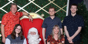 Santa photographer Catherine Ward (bottom left) with greyhound Cody,poses in her family’s Santa photo at Westfield Knox shopping centre. With her father Jeff,mum Karen (holding Jack Russell terrier cross Tyson),and brothers Leighton and Daniel.