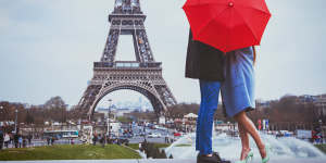 A couple embrace at the Eiffel Tower,Paris. It’s such a cliche. 