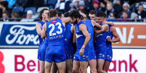 North Melbourne players celebrate with debutant Cooper Harvey.