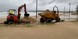 Sand is washed over Marine Parade in Maroubra on Tuesday after heavy rain and damaging surf.