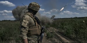 A Ukrainian soldier watches a Grad multiple launch rocket system firing shells with flyers near Bakhmut,Donetsk region.