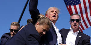 Republican presidential candidate former President Donald Trump is surrounded by US Secret Service agents at a campaign rally.