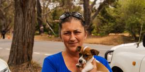 Lorie Kavanagh,with her puppy,Archie,waits at the roadblock on the road into Buxton and other fire-affected communities. 