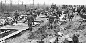 Members of the 2nd Australian Pioneer Battalion build a wagon track from planks at Chateau Wood in Belgium. 