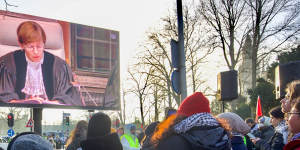 Pro-Palestinian demonstrators watch proceedings at the ICJ on a large screen in The Hague,Netherlands.