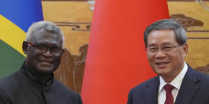 Solomon Islands Prime Minister Manasseh Sogavare,left,shakes hands with his Chinese counterpart Li Qiang in Beijing,July 2023.