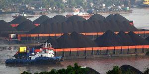 Tugboats guide barges transporting coal in Indonesia.