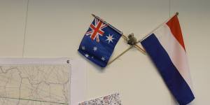 An Australian and Dutch flag hang on the wall next to maps showing the flight path of MH17 in the National Police of the Netherlands criminal investigation building in 2015. 