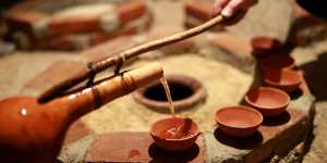 Pouring wine from a qvevri (earthenware vessel used for fermentation) using an orshimo (traditional ladle).
