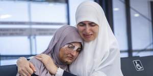 Ranem Abu Izneid is embraced by her mother,Rana,at Melbourne Airport on Sunday.