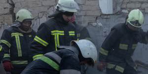 Firefighters work to clear the rubble at a destroyed village shop and café in Hroza,Ukraine. 