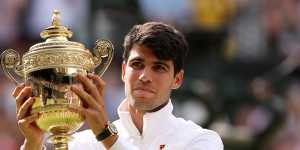 Carlos Alcaraz of Spain poses with the trophy after retaining his Wimbledon title.