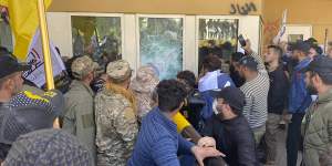 Protesters smash a window inside the US embassy compound,in Baghdad,on December 31.