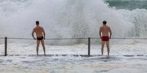 Weather. Mikey and Patch May check out the wild surf conditions from the Cronulla rock pool.