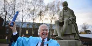 Professor Peter Higgs,poses for photographs in front of a statue of James Watt after receiving an honorary degree of doctor of science,from Heriot-Watt University,Edinburgh,2012.