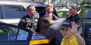 Law enforcement officers detain Hadi Matar (centre) following the stabbing of Salman Rushdie.