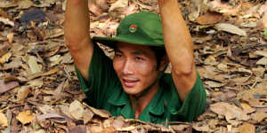 Vietnamese soldier gliding into the entrance of the Viet Cong tunnel system in Cu Chi.