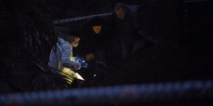 By nightfall,forensic officers in white suits were huddled over the bones with torchlights.