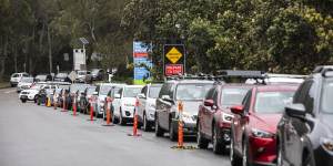 A long line of cars wait at the Mona Vale Hospital drive-through clinic on Monday morning. 