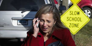 A woman mourns while speaking on the phone near Sandy Hook Elementary School,after the December 2012 shooting there which left 20 children and six school staff dead.