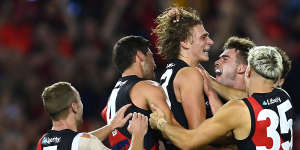 Harrison Jones is congratulated by team mates after kicking a goal during the round three match between the Bombers and St Kilda at Marvel Stadium.