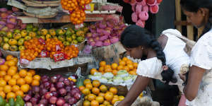 A woman selects apples at a produce stall in Galle,Sri Lanka.