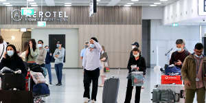 Passengers walk through the international arrivals terminal in Sydney airport in December.
