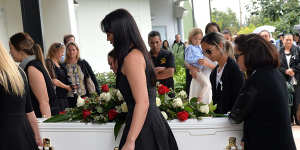 Friends and family carry Tara Brown's coffin into her funeral service.