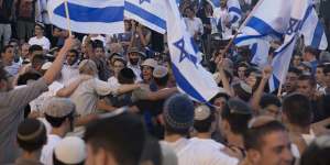Ultra-nationalist Israelis dance with Israeli flags as they march near Damascus Gate.