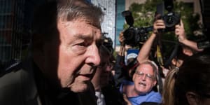George Pell outside Victoria's County Court,where hecklers yelled that the cardinal was going to"burn"and"rot"in hell.
